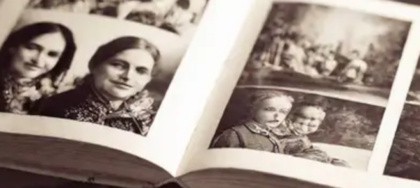 A sepia toned image of an open photograph album with family photos.
